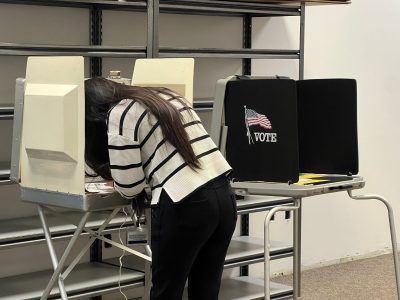 A photo of a person casting a ballot at a mock vote center.
