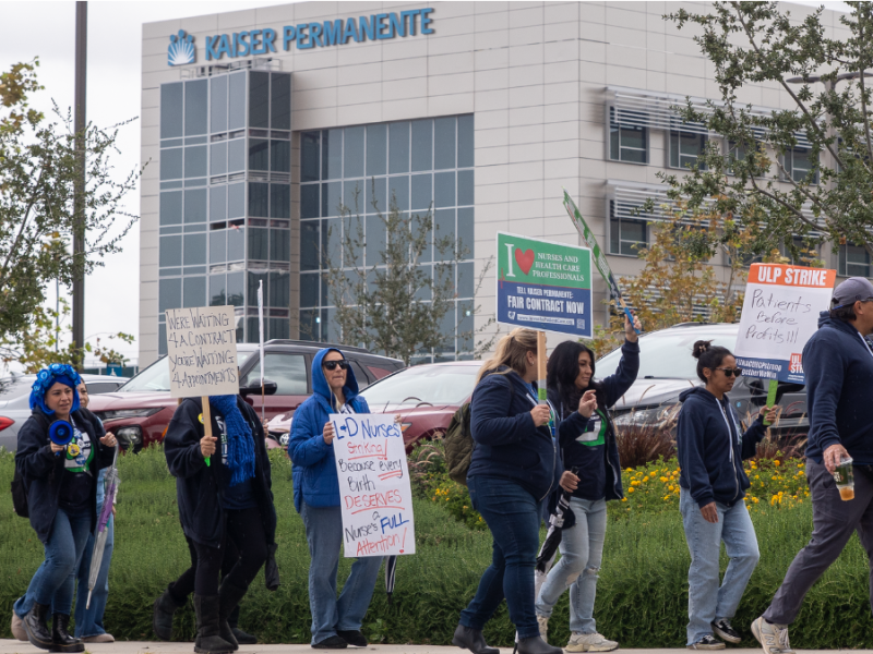 A picket line of striking healthcare workers outside of a hospital.