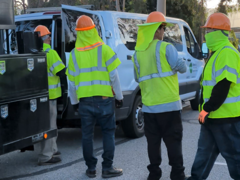 A group of men in high-visibility vests.