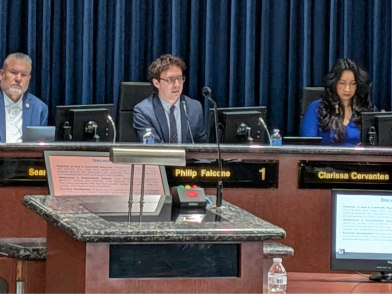 The three council members sit at the dais.
