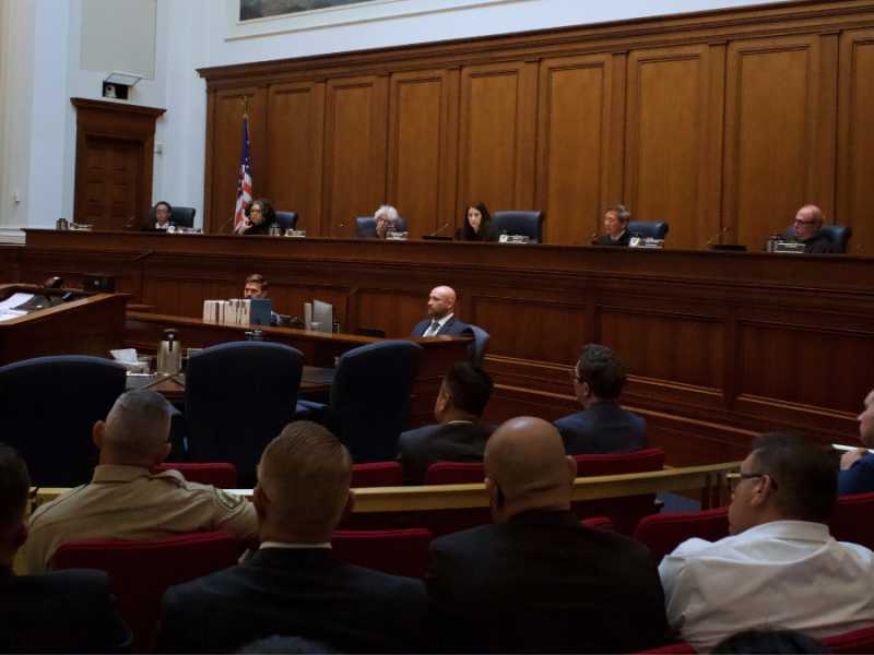A man at a lecturn making a statement to a courtroom and a panel of justices.